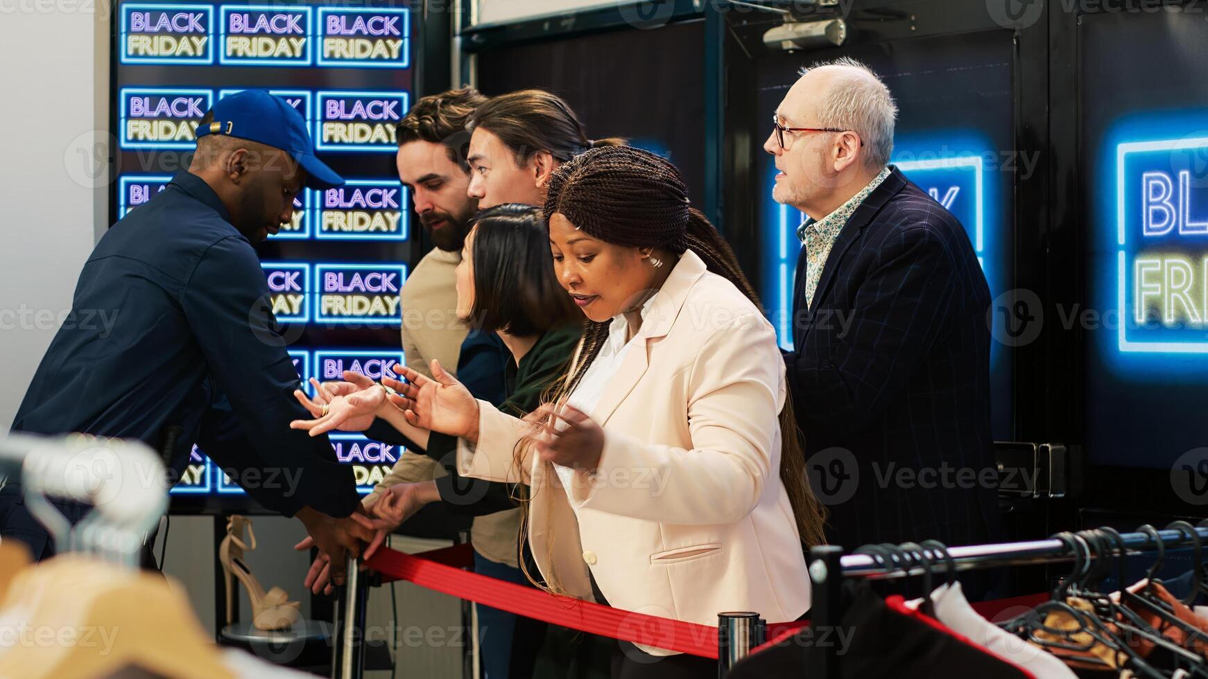 Clients acting crazy on black friday, guard opening retail store and letting aggressive shoppers in. Asian man being pushed on the floor by mad anxious crowd, seasonal sales madness. photo