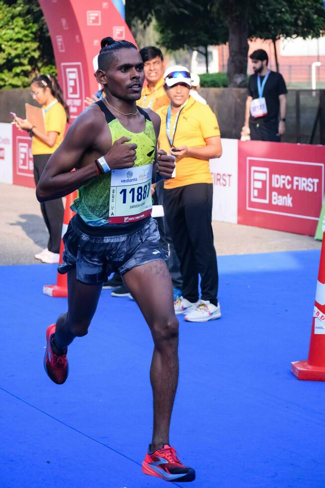 nueva delhi, india - 16 de octubre de 2022 - carrera de media maratón de vedanta delhi después de covid en la que los participantes del maratón están a punto de cruzar la línea de meta, media maratón de delhi 2022 foto