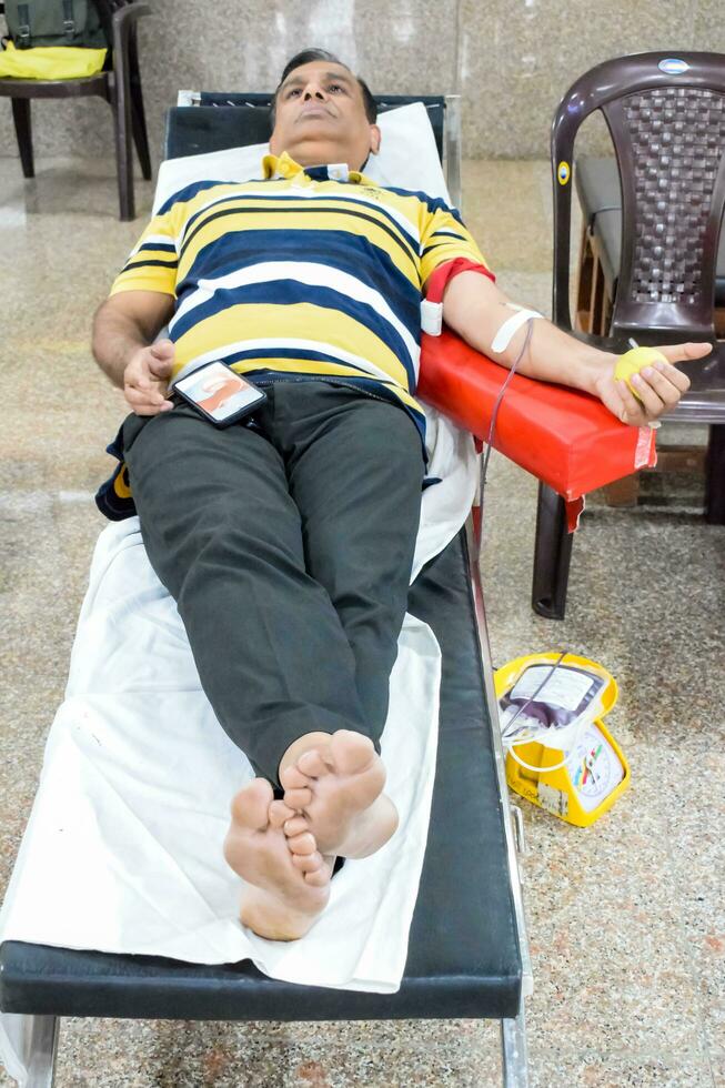 Delhi, India, June 19 2023 - Blood donor at Blood donation camp held at Balaji Temple, Vivek Vihar, Delhi, India, Image for World blood donor day on June 14 every year, Blood Donation Camp at Temple photo