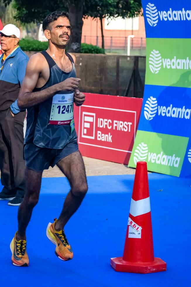 nuevo Delhi, India - julio dieciséis 2023 - vedanta Delhi medio maratón carrera después codicioso en cuales maratón Participantes acerca de a cruzar el terminar línea, Delhi medio maratón 2022 foto