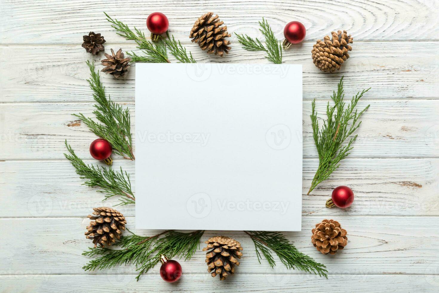 Flat lay Christmas composition. square Paper blank, pine tree branches, christmas decorations on Colored background. Top view, copy space for text photo