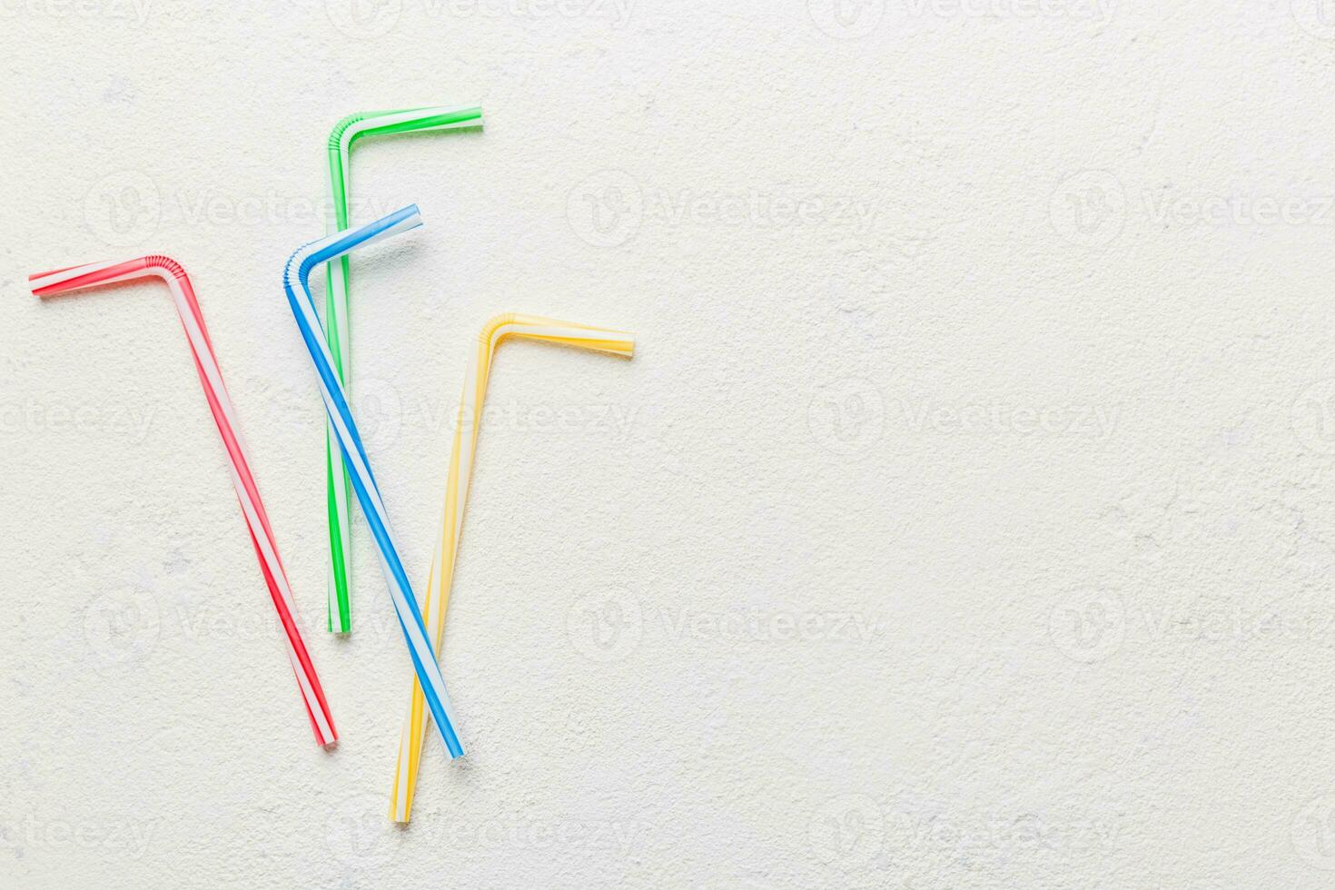 Drinking straws for party on Colored background. Top view of colorful plastic disposable straws for summer cocktails. different straws for juice with copy space photo