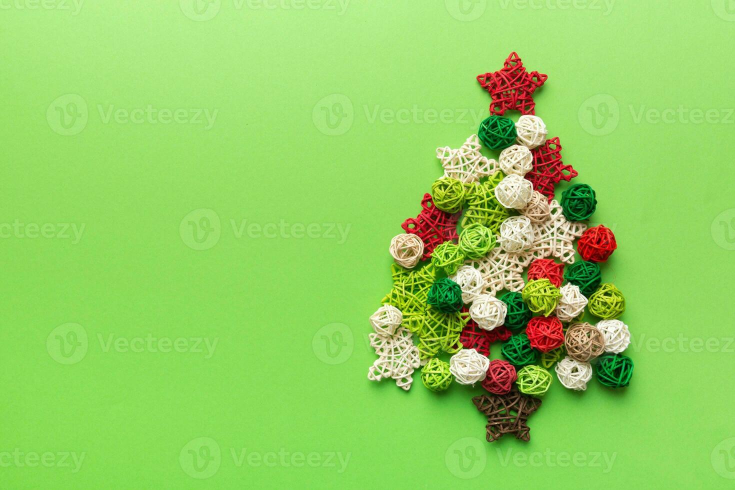 Christmas tree made from colored handmade ball decoration on colored background, view from above. New Year minimal concept with copy space photo