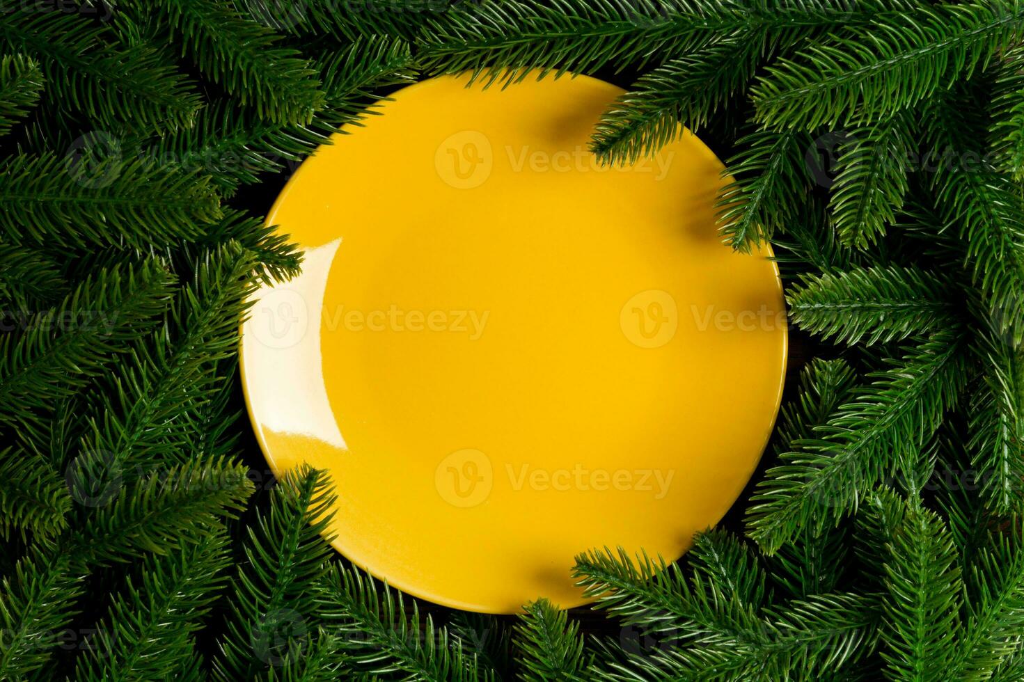 Top view holiday plate among green fir tree branches. Christmas dinner with copy space photo