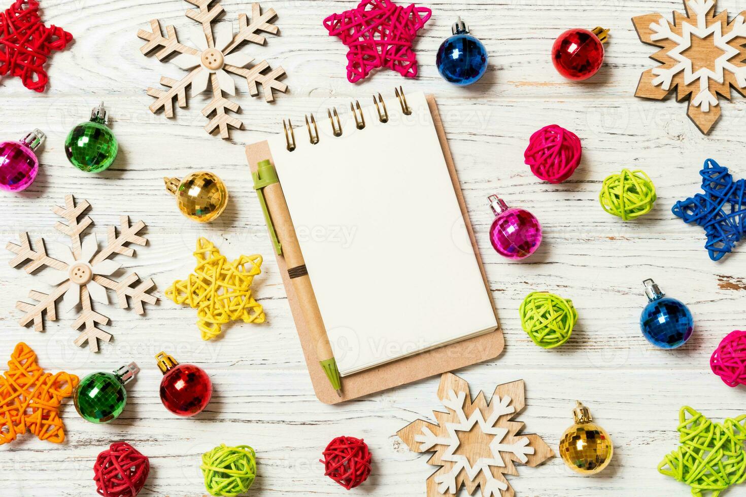 Top view of notebook on wooden background made of Christmas decorations. New Year concept photo