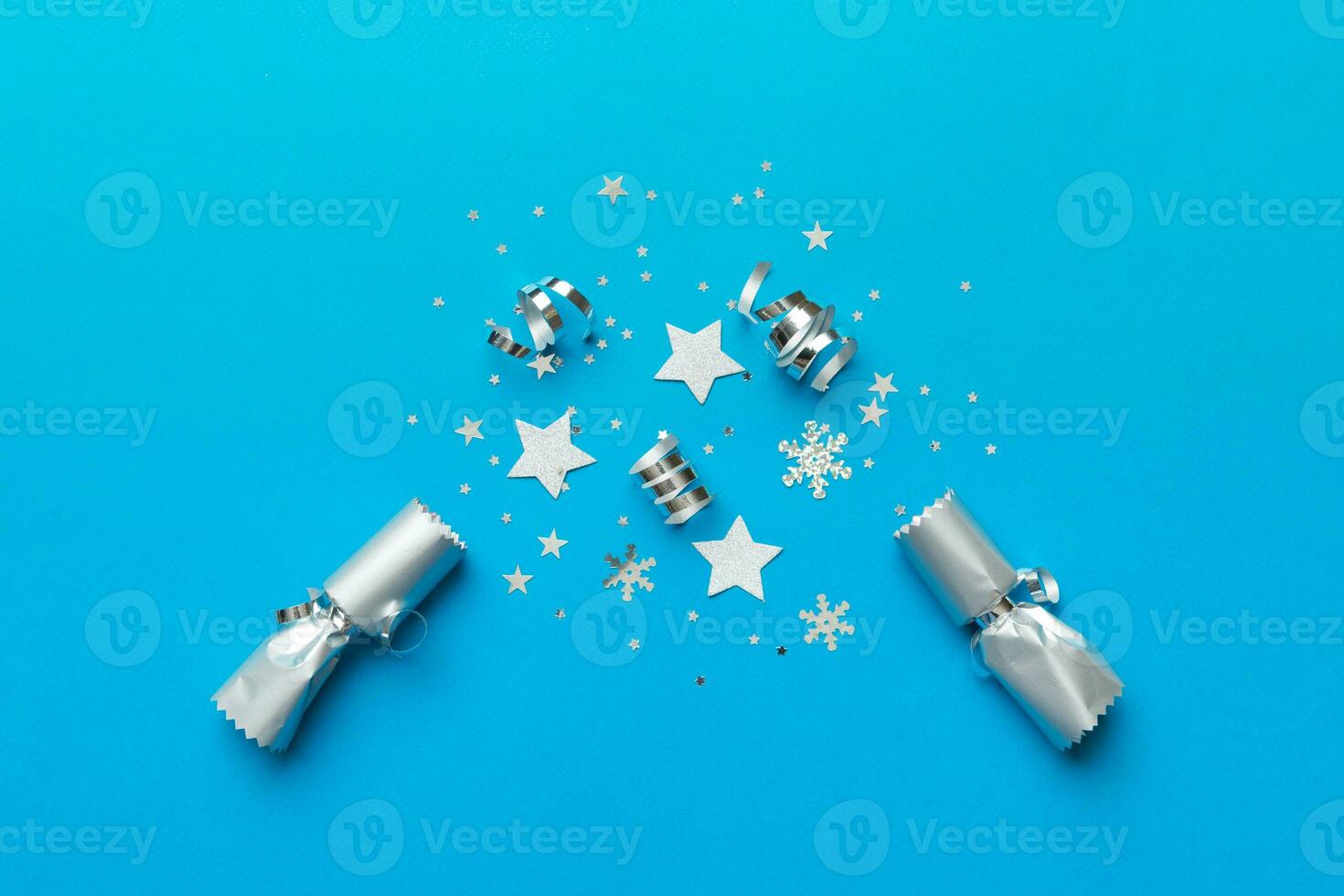 Christmas crackers with shiny confetti on color background, top view, copy space photo