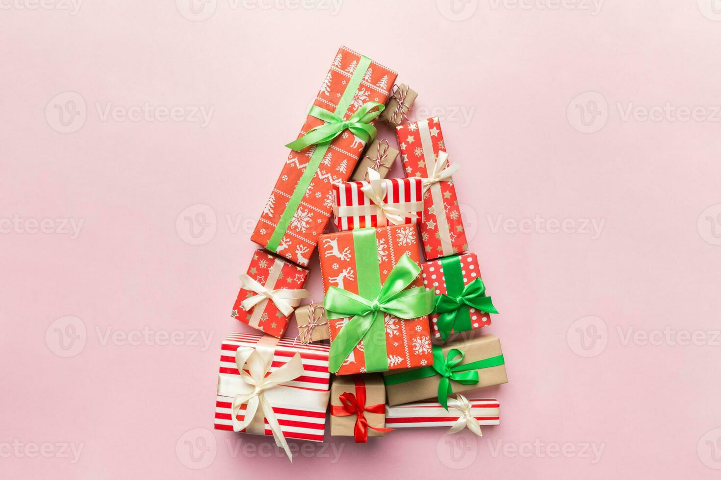 Christmas tree made of beautifuly wrapped presents on colored background, view from above. New Year gift box minimal concept with copy space photo