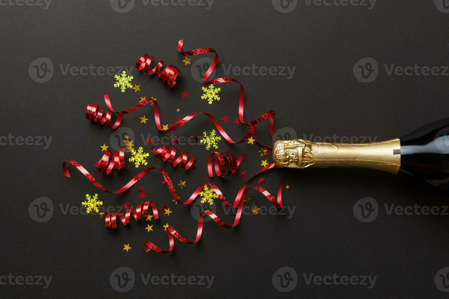 Creative flat lay composition with bottle of champagne and space for text on color background. Champagne bottle with colorful party streamers. holiday or christmas concept photo