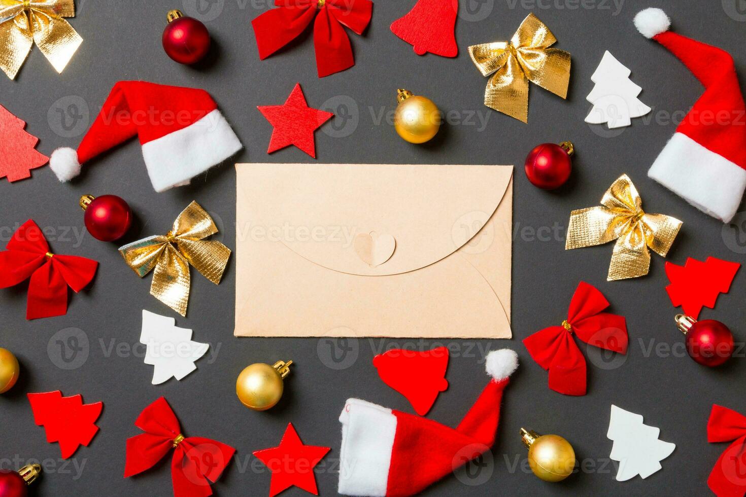 Top view of craft envelope on black background with New Year toys and decorations. Christmas time concept photo