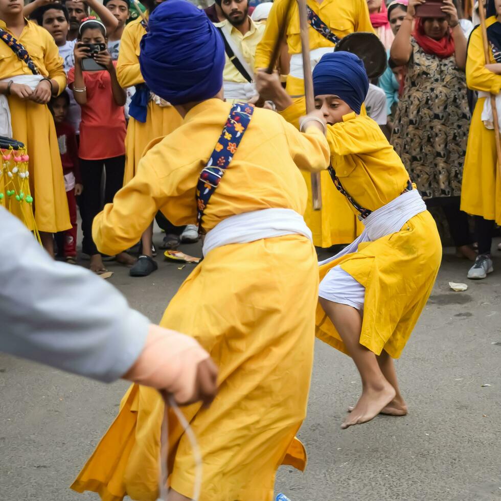 Delhi, India, October 2, 2023 - Sikhs display gatka and martial arts during annual Nagar Kirtan, Traditional, procession on account of birthday of Guru Nanak Dev ji, Nagar Kirtan in East Delhi area photo