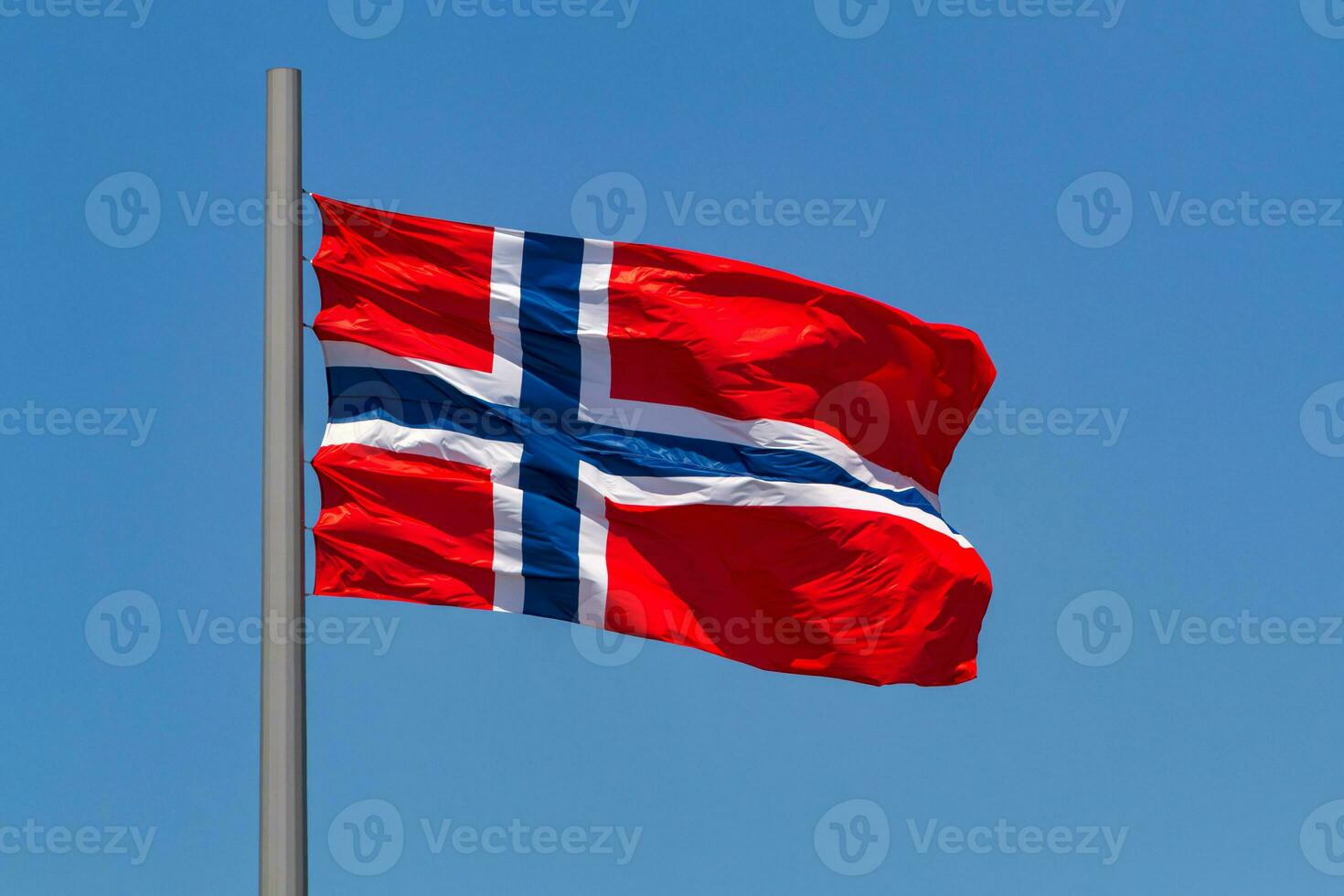 Norwegian flag waving in the wind against blue sky. photo