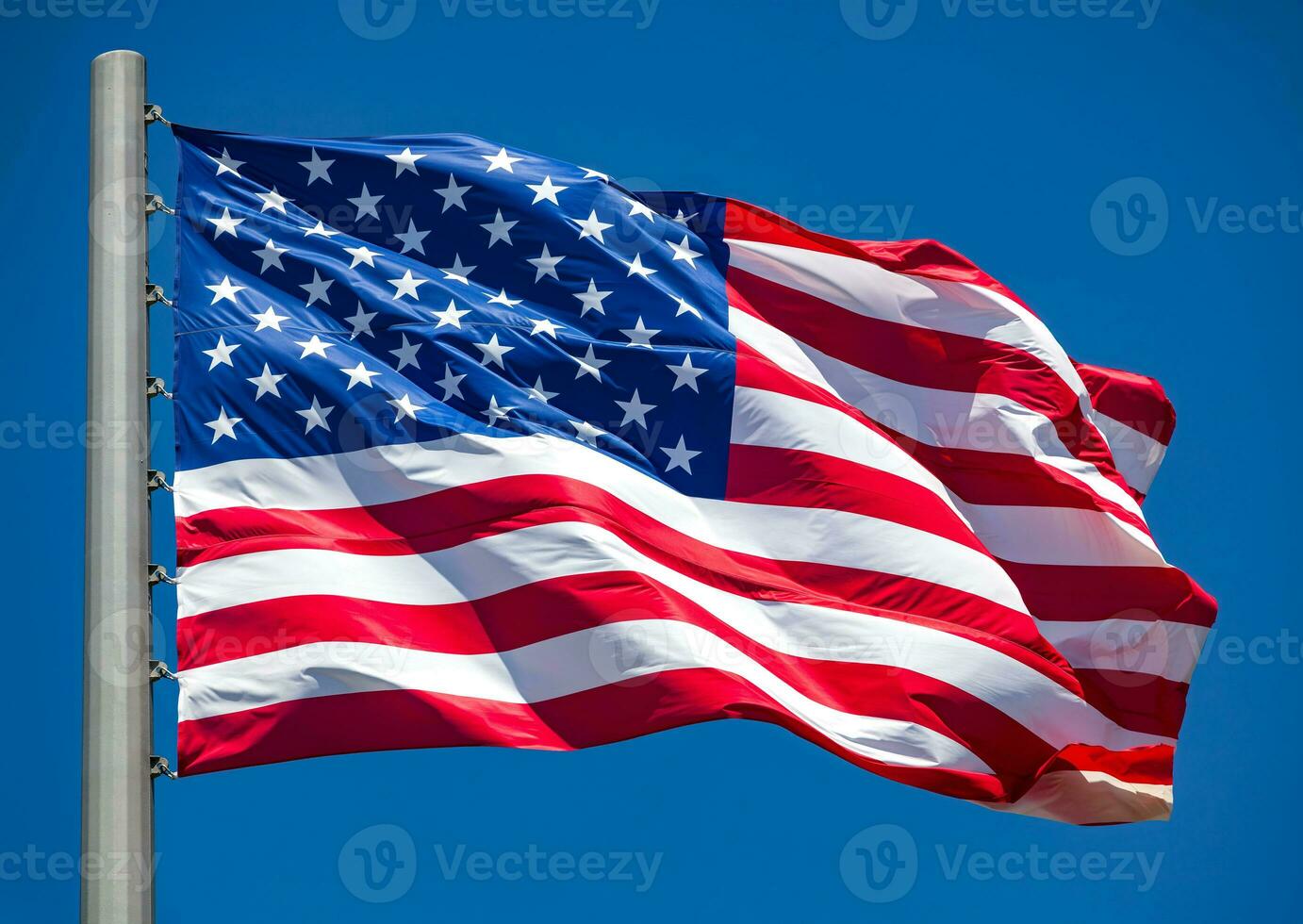 American flag waving in the wind against blue sky photo