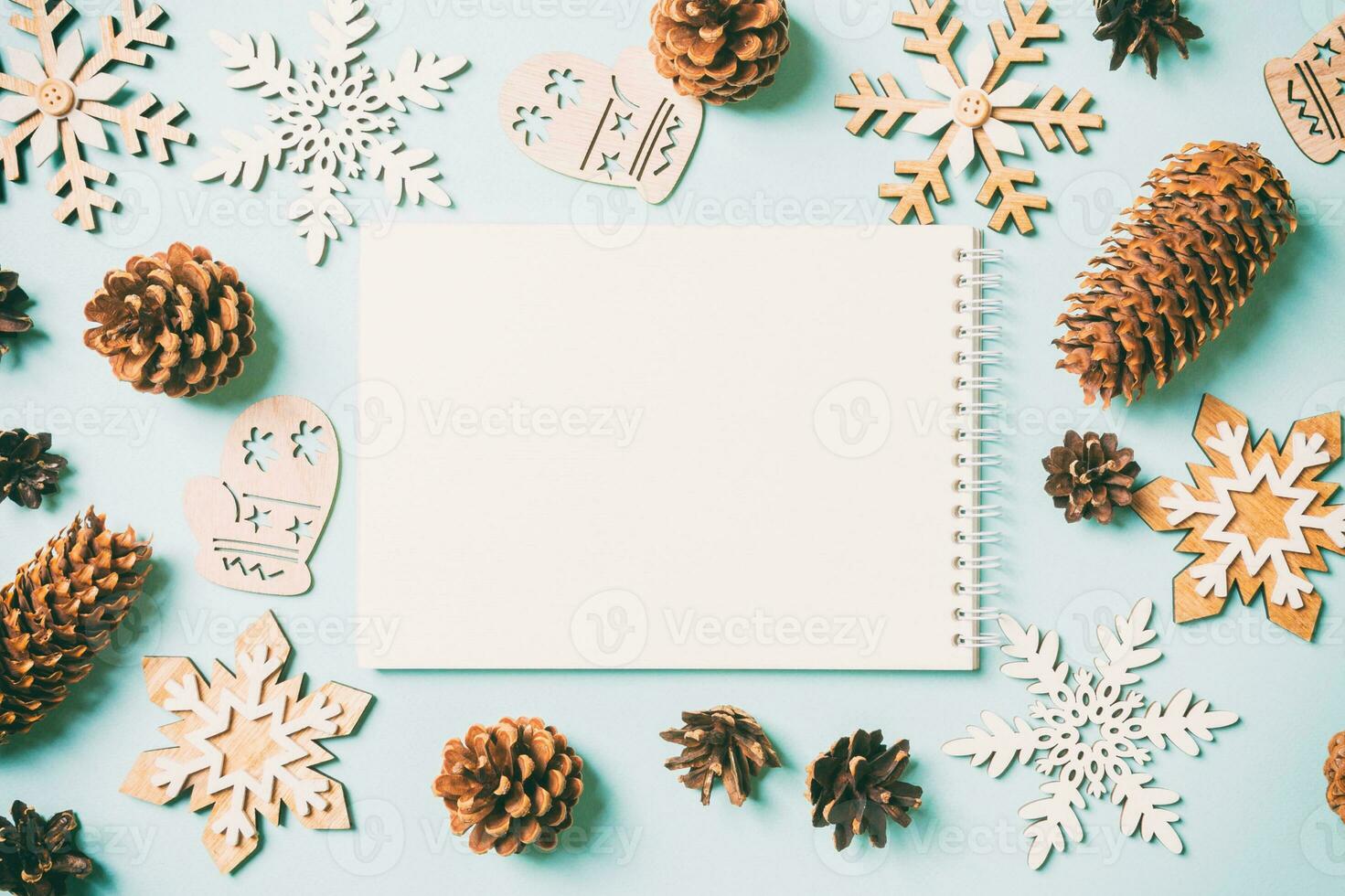 Top view of notebook, holiday toys and decorations on blue Christmas background. New Year time concept photo
