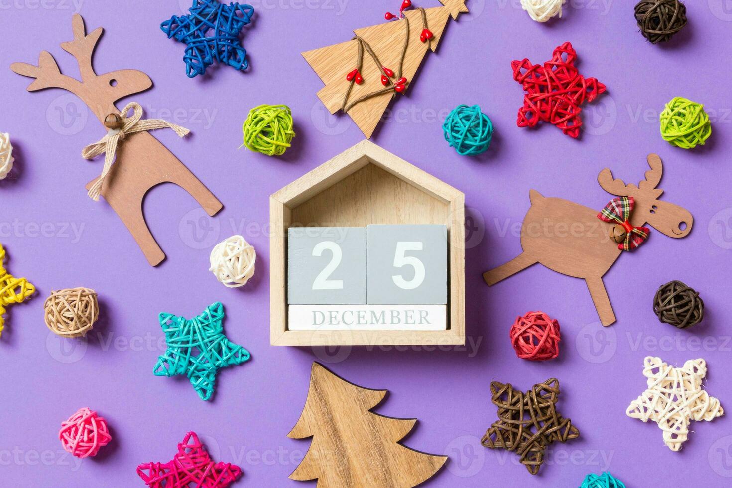 Top view of wooden calendar. The twenty fifth of December. New Year decorations on purple background. Festive stars and balls. Merry Christmas concept photo