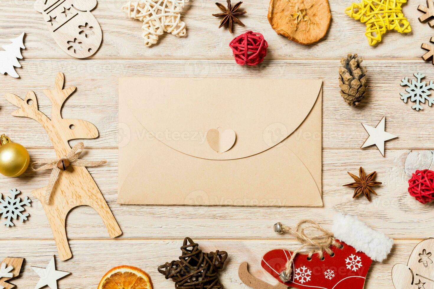Top view of envelope on festive wooden background. Christmas toys and decorations. New Year time concept photo