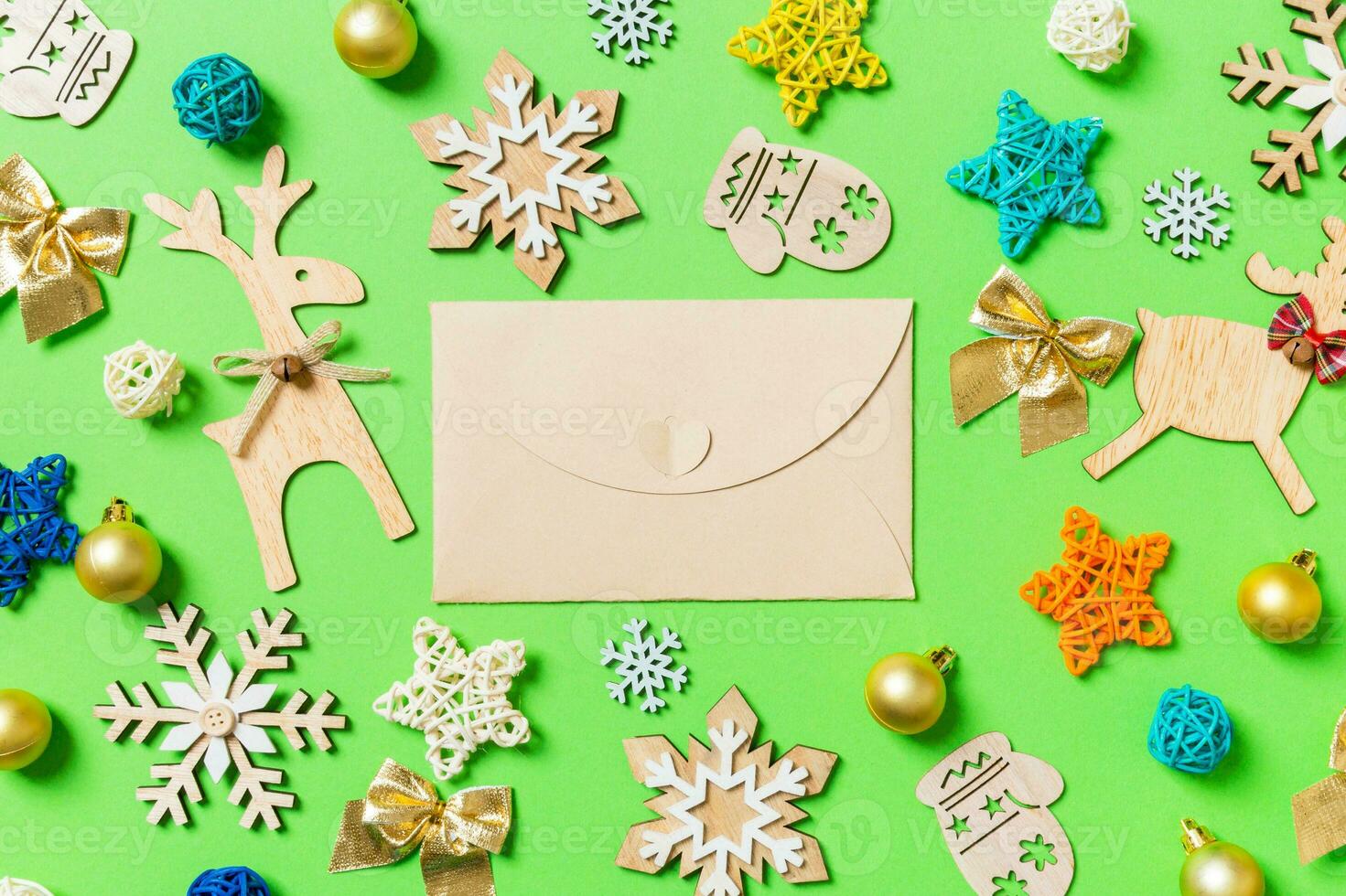 Top view of craft envelope on green background with New Year toys and decorations. Christmas time concept photo