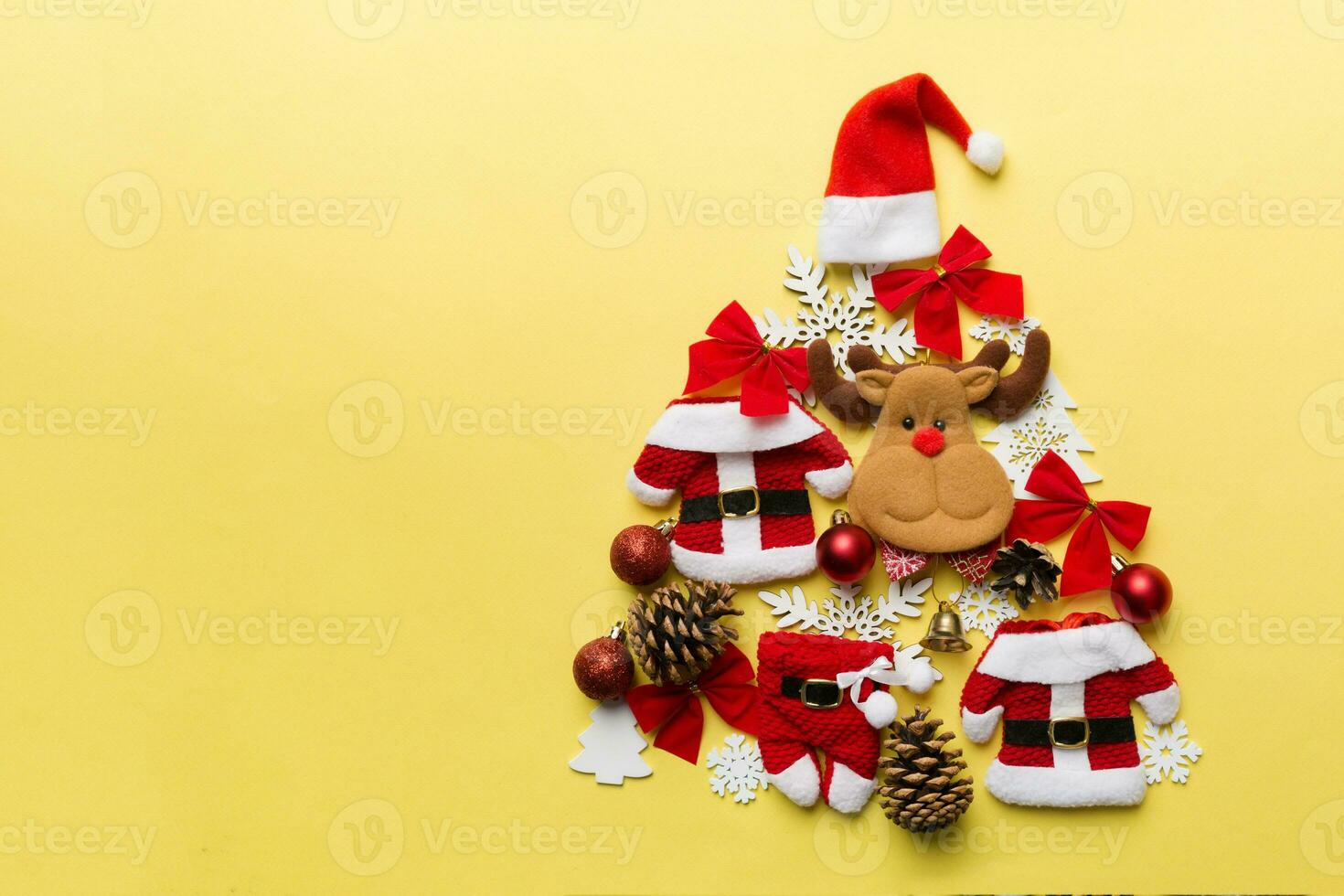Christmas tree made from colored suit santa decoration on colored background, view from above. New Year minimal concept with copy space photo