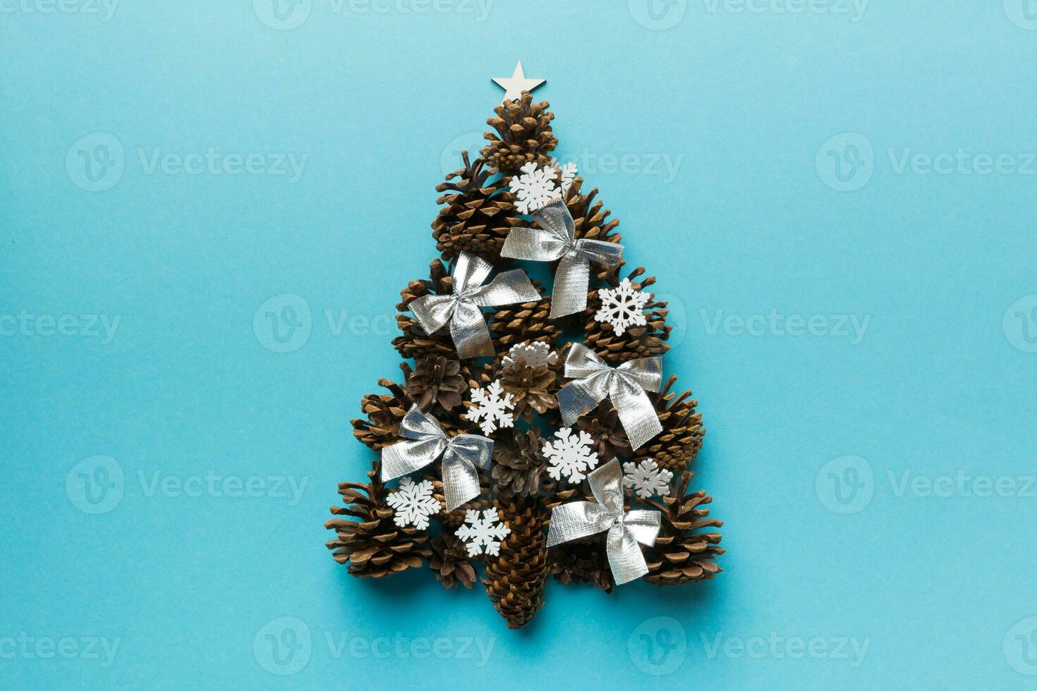 Christmas tree made from natural cones on colored background, view from above. New Year minimal concept with copy space photo