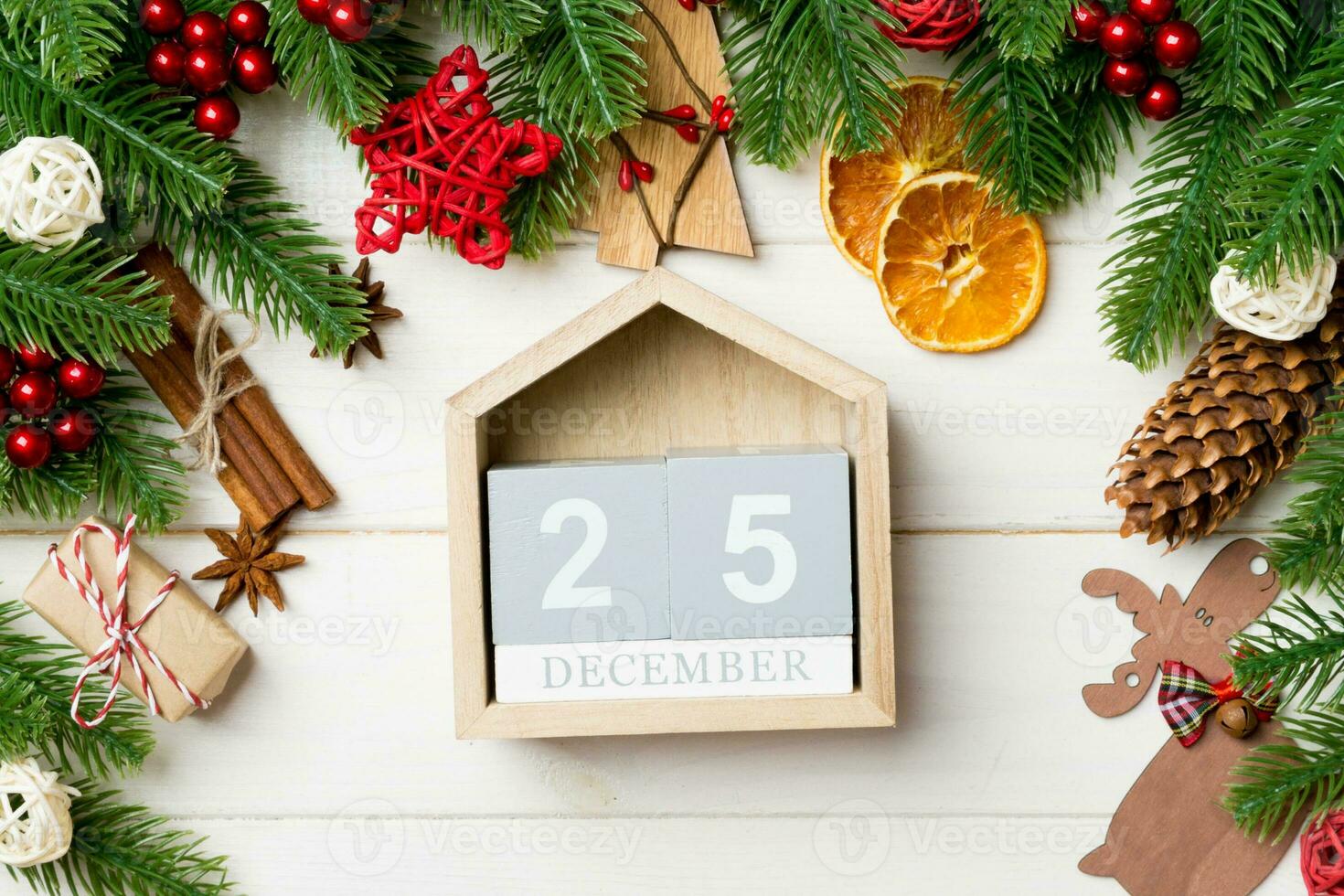 Top view of fir tree branches on wooden background. Calendar decorated with festive toys. The twenty fifth of December. Christmas time concept photo