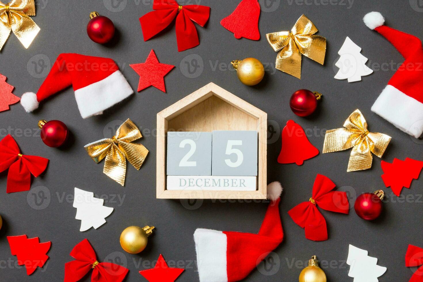 Top view of wooden calendar on black background with New Year toys and decorations. The twenty fifth of December. Christmas time concept photo