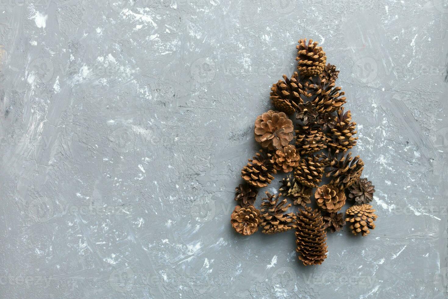 Christmas tree made from natural cones on colored background, view from above. New Year minimal concept with copy space photo