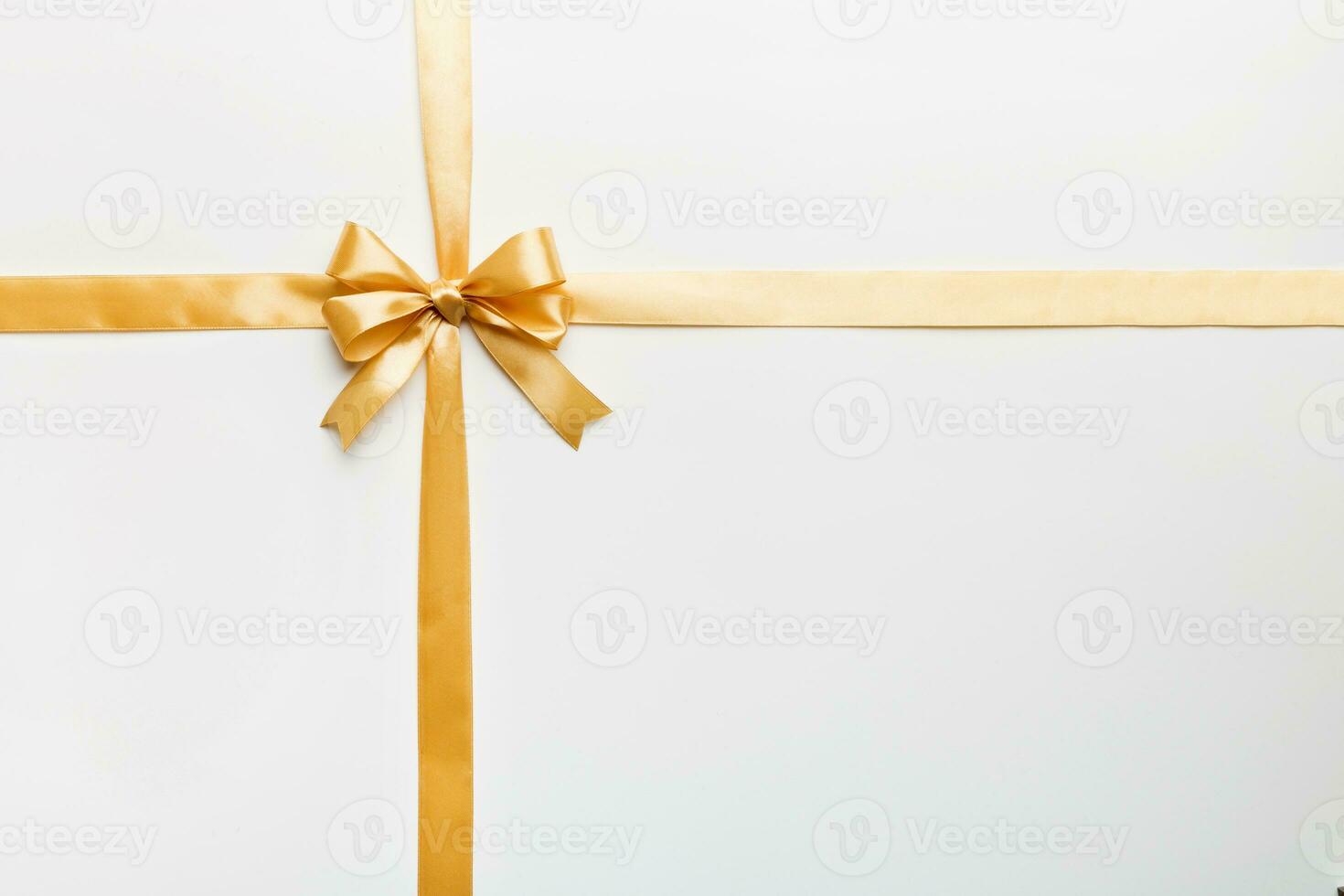 Top view of gold ribbon rolled and yellowbow isolated on colored background. Flat lay with copy space photo