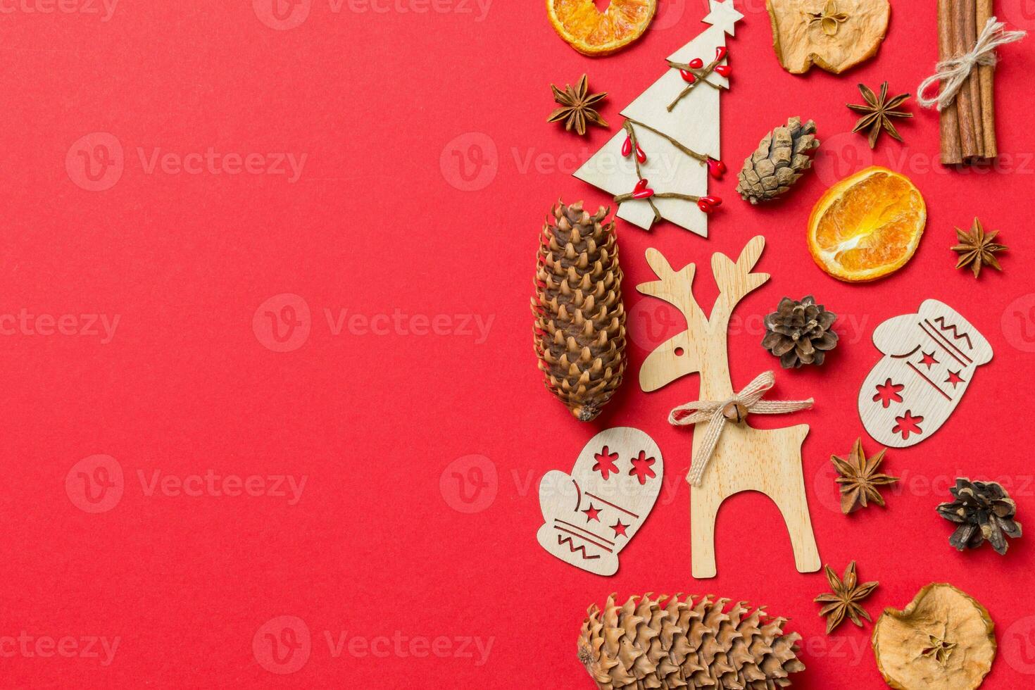 Top view of red background decorated with festive toys and Christmas symbols reindeers and New Year trees. Holiday concept with copy space photo