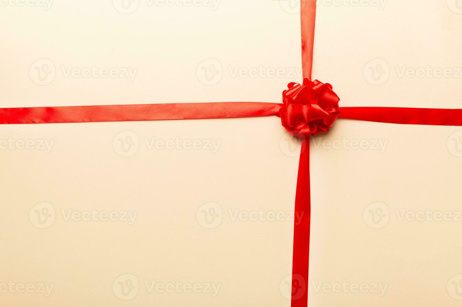 Top view of Red ribbon rolled and red bow isolated on colored background. Flat lay with copy space photo