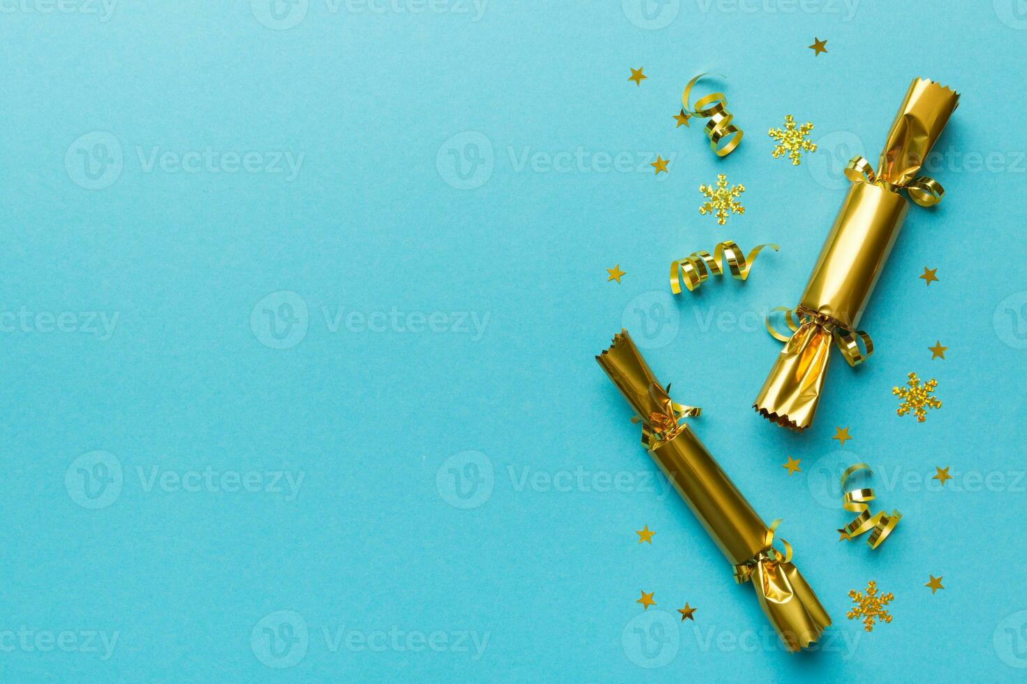 Christmas crackers with shiny confetti on color background, top view, copy space photo