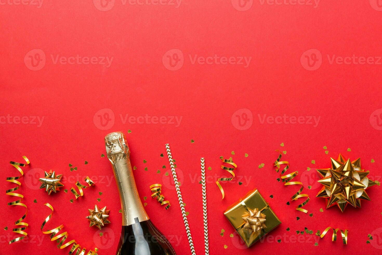 Bottle of champagne with colored glitter, confetti and gift box space for text on colorfull background, top view. Hilarious, christmas and birthday celebration photo