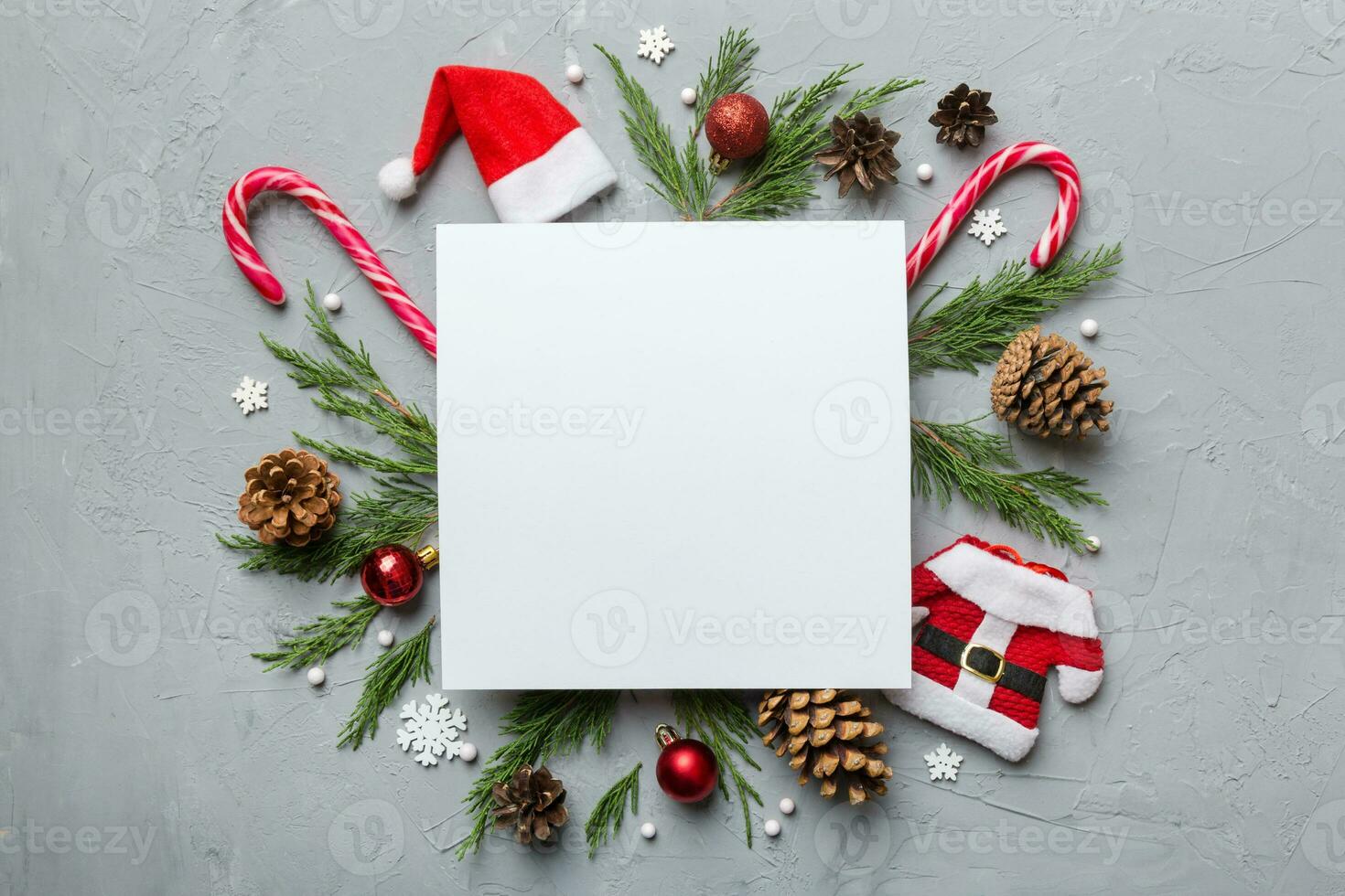 Flat lay Christmas composition. square Paper blank, pine tree branches, christmas decorations on Colored background. Top view, copy space for text photo