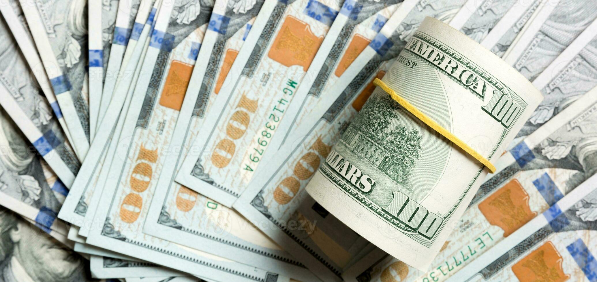Top view of 100 rolled dollar bills on background made with one hundred dollar banknotes. Business concept photo