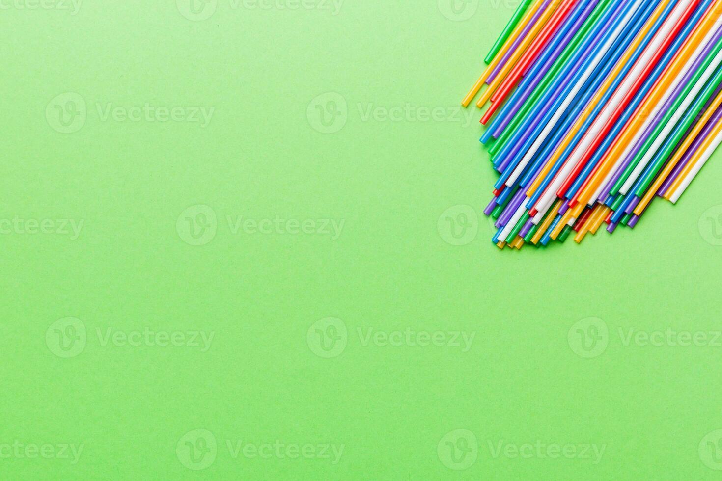 Heap of colorful plastic drinking straws on Colored background, flat lay. Copy Space for text photo