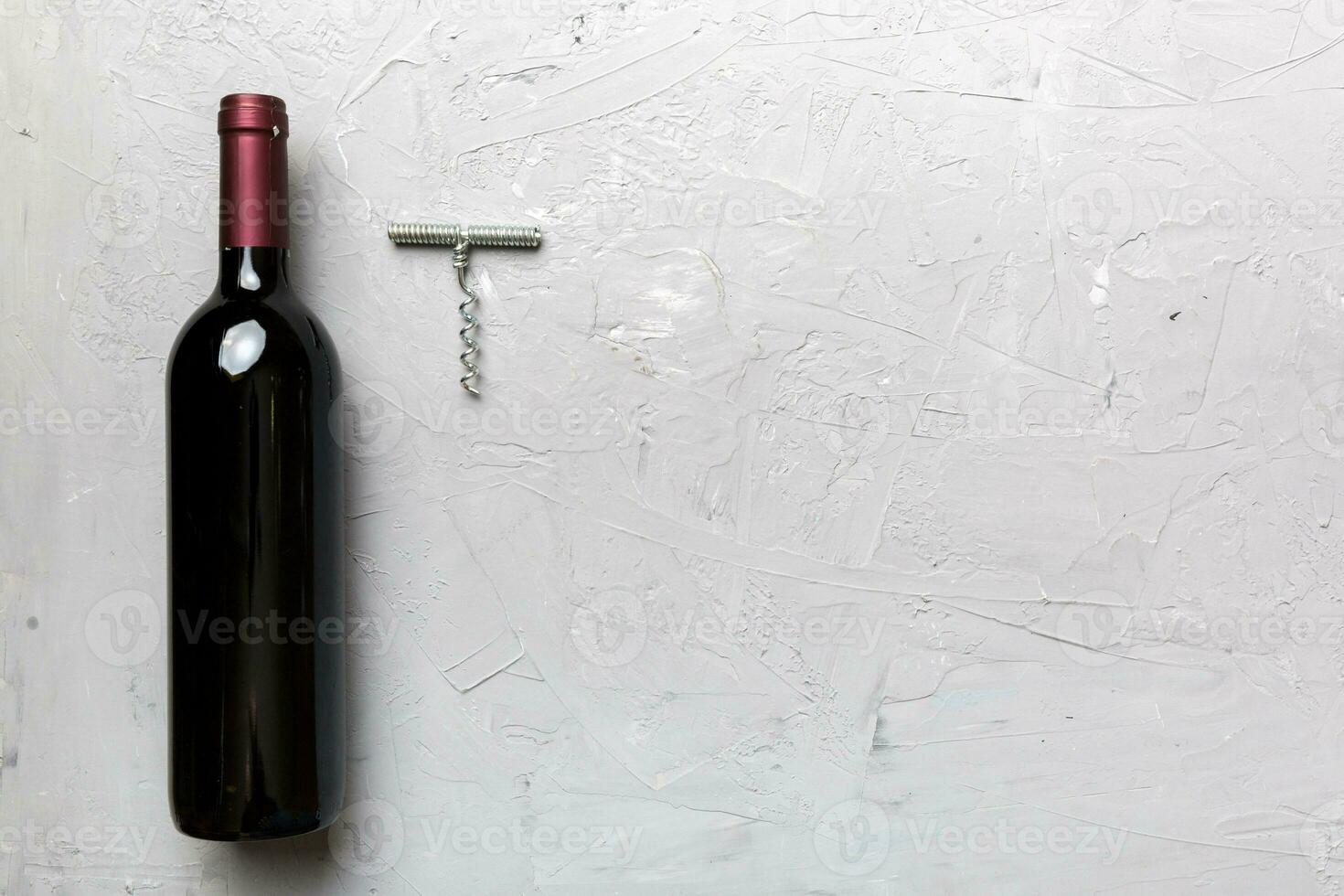 One Bottle of red wine with corkscrew on colored table. Flat lay, top view wth copy space photo