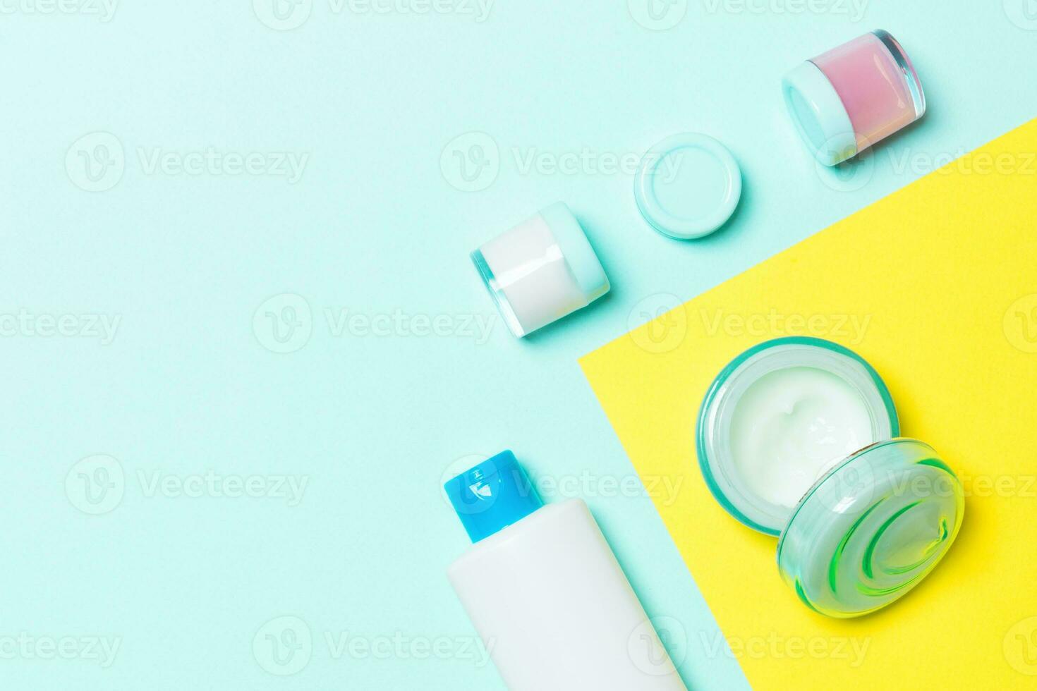 Group of plastic bodycare bottle Flat lay composition with cosmetic products on yellow and blue background empty space for you design. Set of White Cosmetic containers, top view with copy space photo