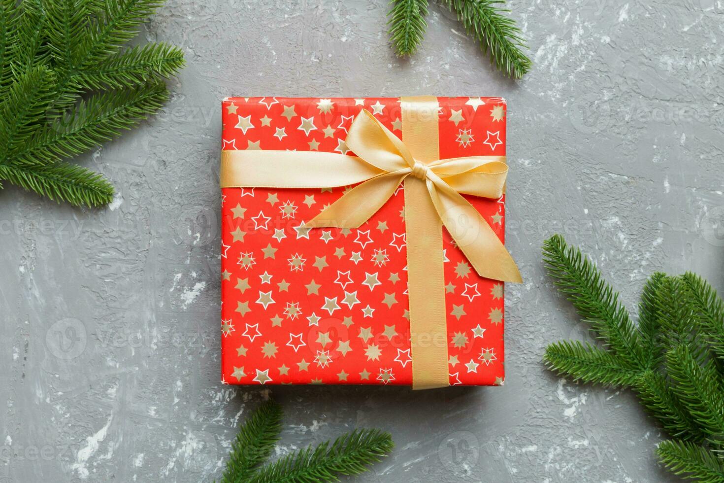 Christmas composition. Christmas gift and fir branches on cement background. Flat lay, top view, copy space photo