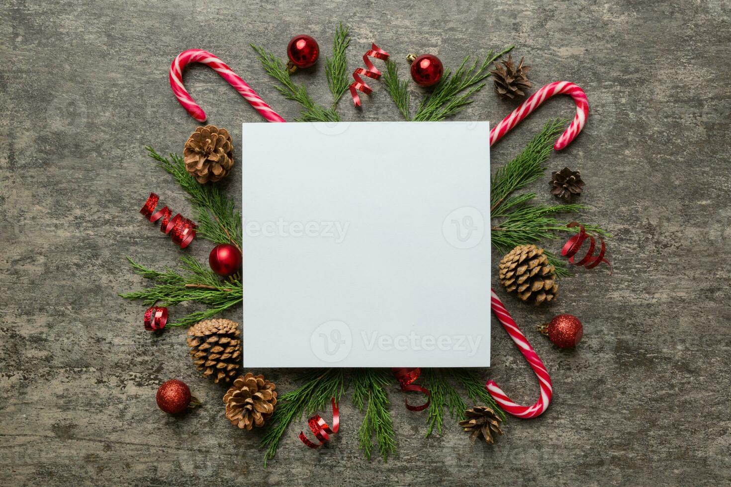 plano laico Navidad composición. cuadrado papel blanco, pino árbol sucursales, Navidad decoraciones en de colores antecedentes. parte superior vista, Copiar espacio para texto foto