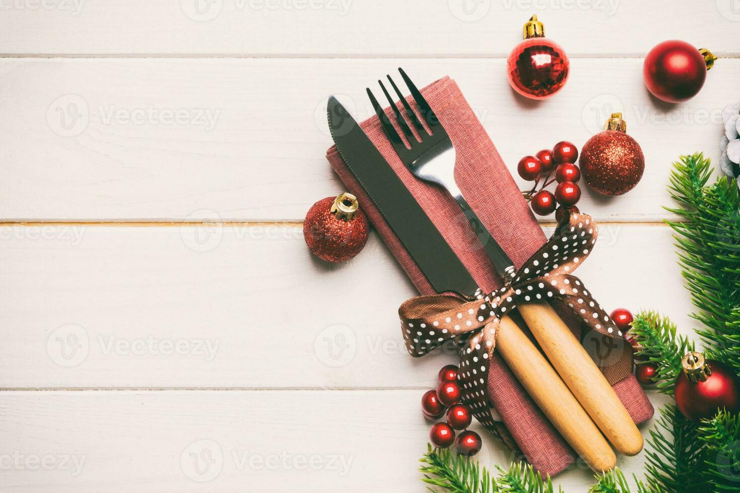Top view of festive cutlery on new year wooden background. Christmas decorations with empty space for your design. Holiday dinner concept photo