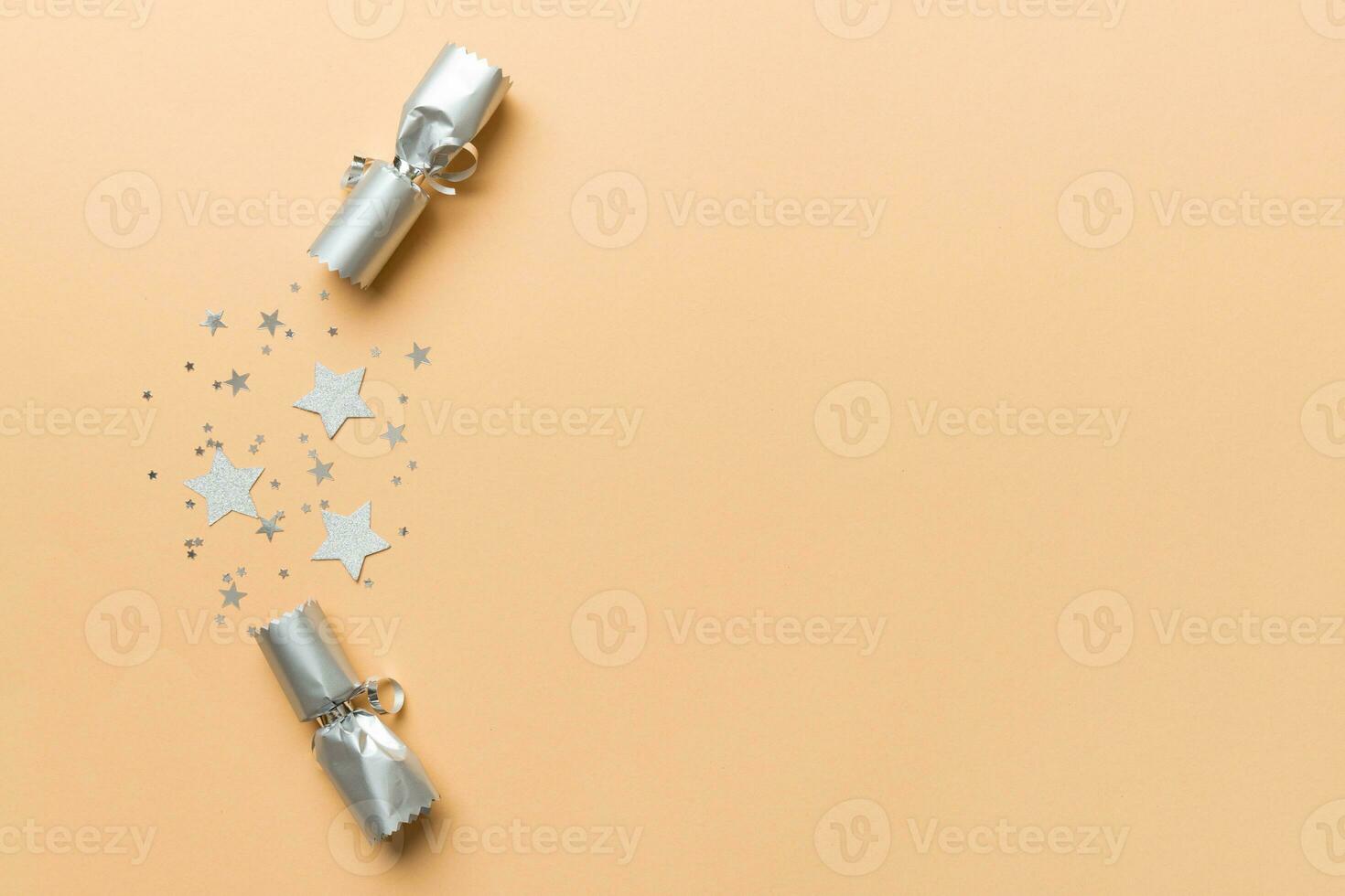 Christmas crackers with shiny confetti on color background, top view, copy space photo