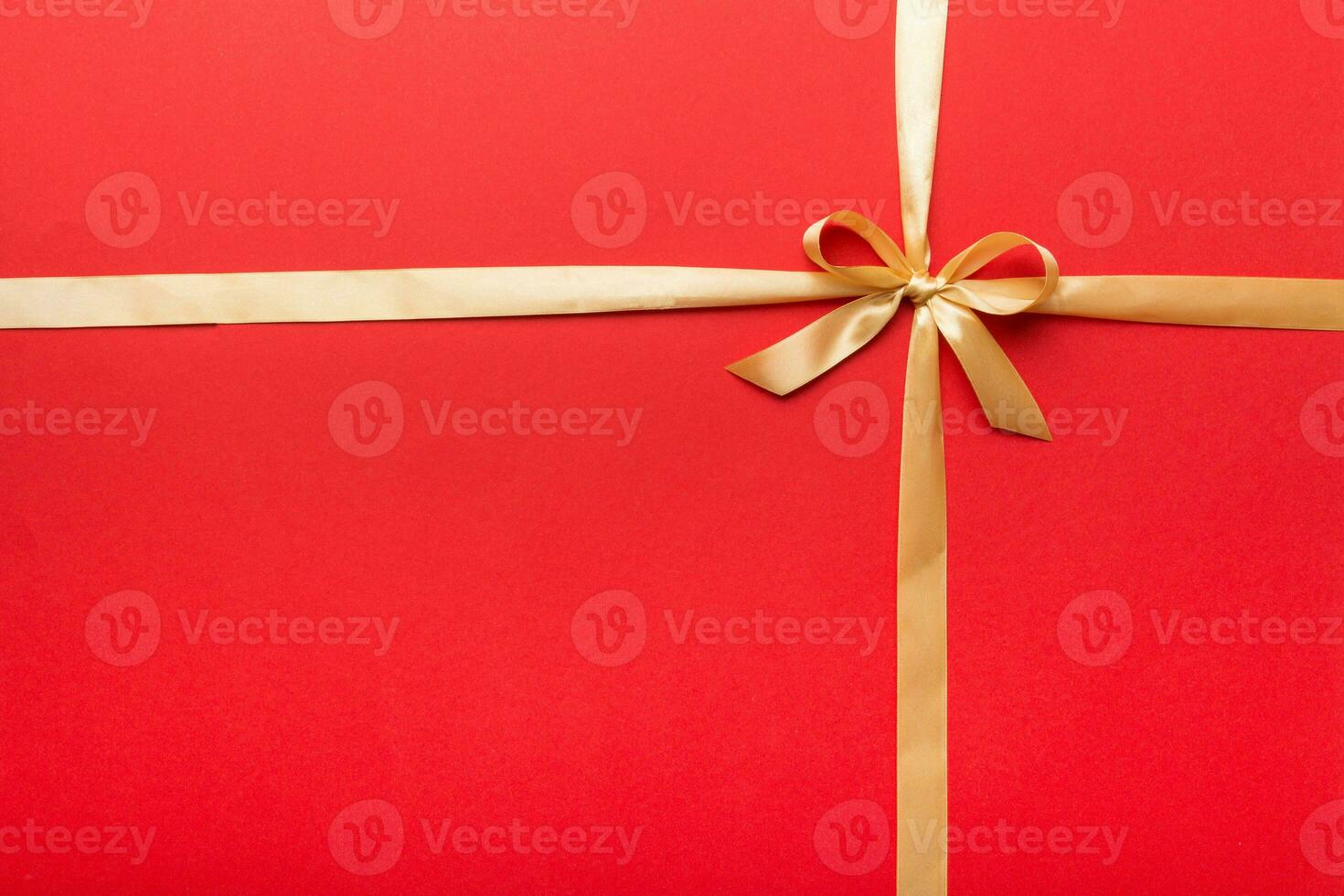 Top view of gold ribbon rolled and yellowbow isolated on colored background. Flat lay with copy space photo