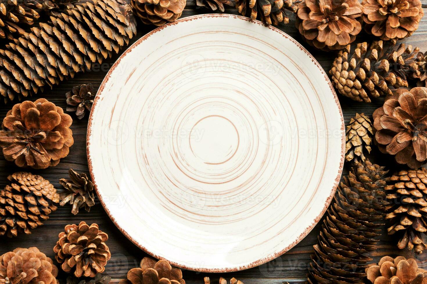 Top view of festive plate with pine cones on wooden background. New Year dinner concept photo