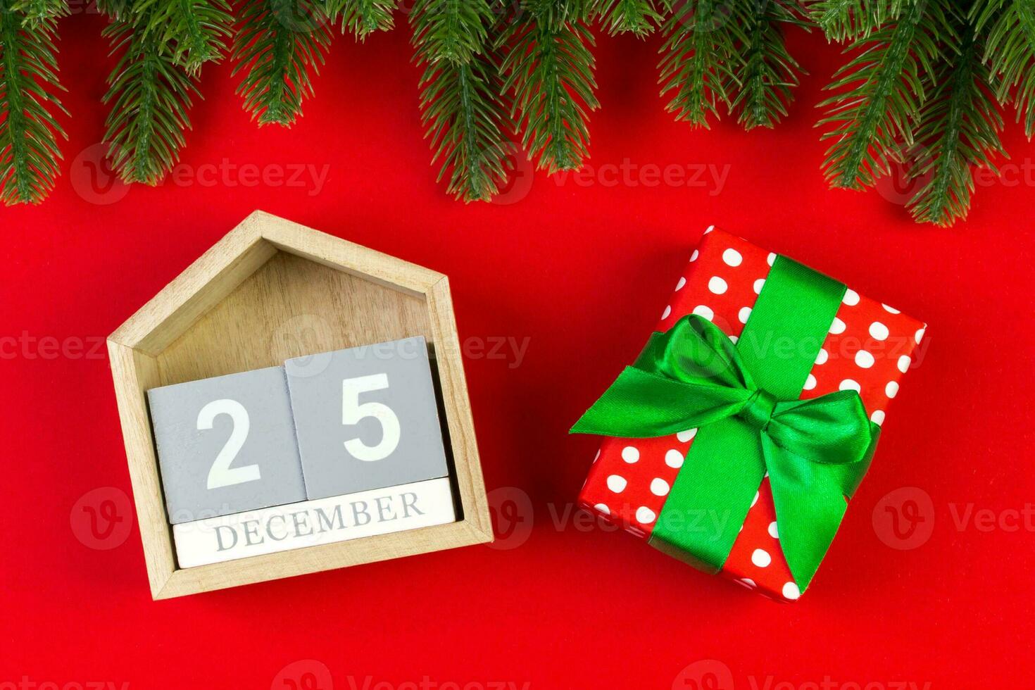 Top view of wooden calendar, gift box and fir tree on colorful background. The twenty fifth of December. Christmas time with copy space photo