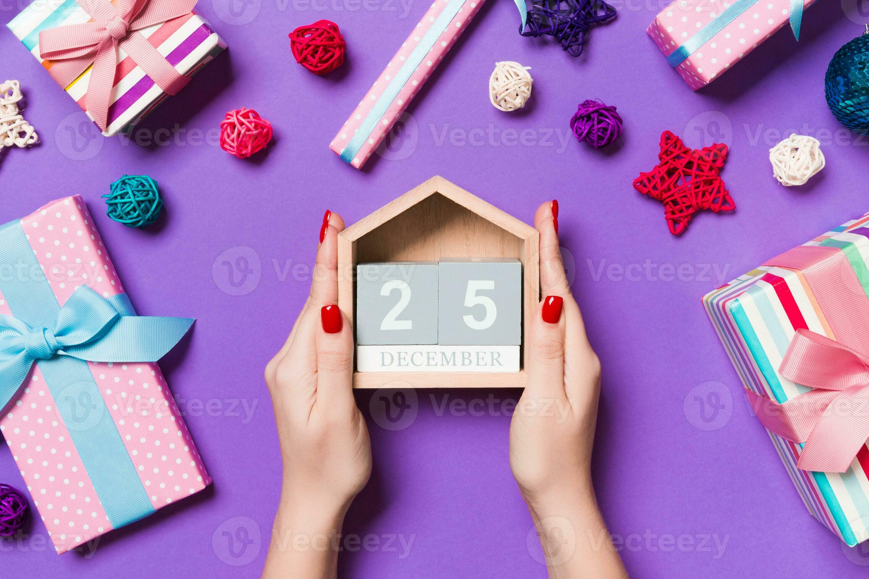 Top View Of Female Hands Holding Calendar On Purple Background The top-view-of-female-hands-holding-calendar-on-purple-background-the