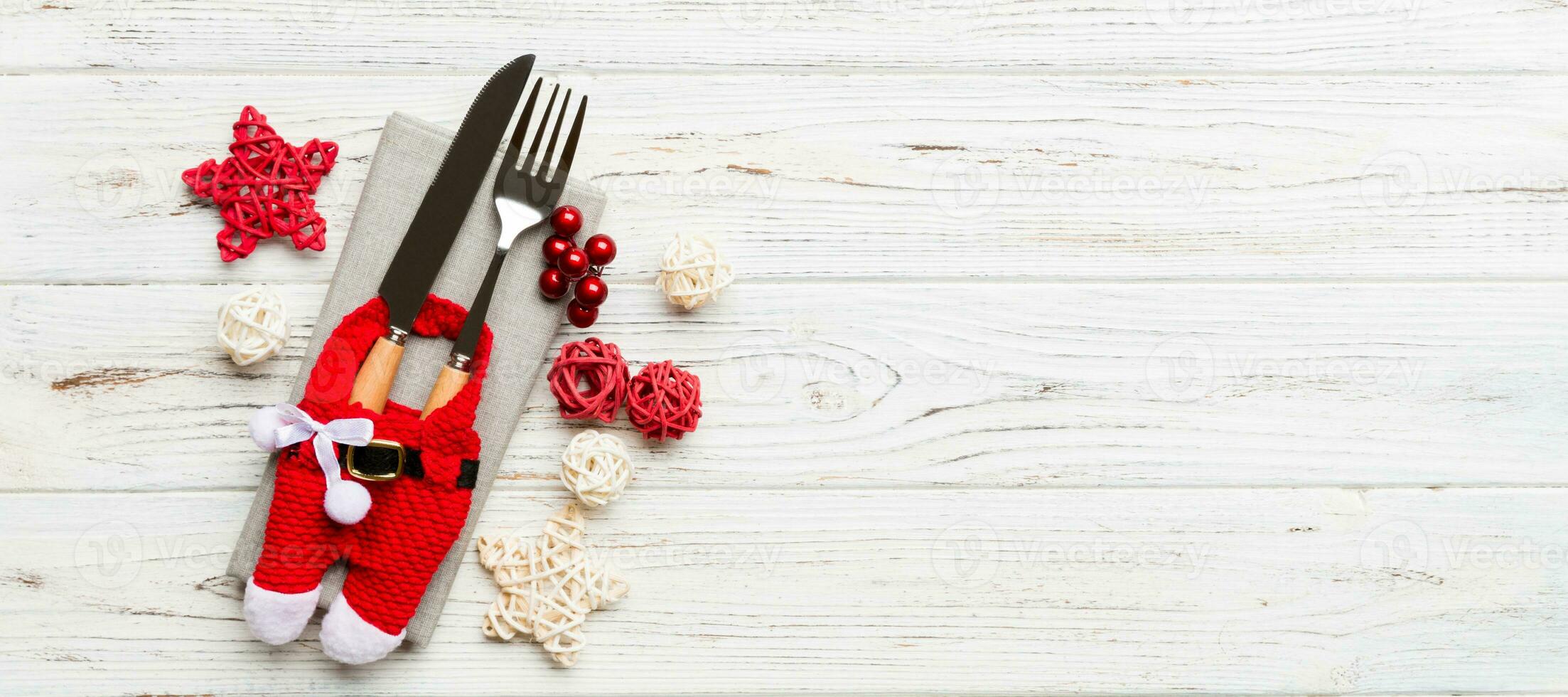 Top view Banner of holiday set of fork and knife on wooden background. Christmas decorations and toys with copy space. New Year Eve concept photo