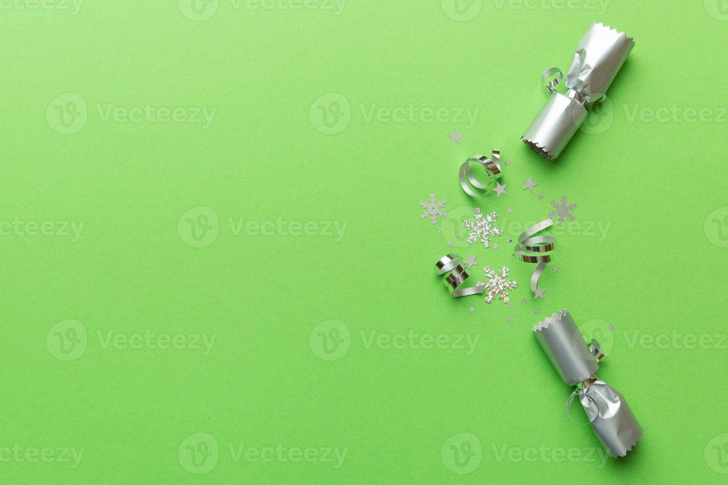 Christmas crackers with shiny confetti on color background, top view, copy space photo