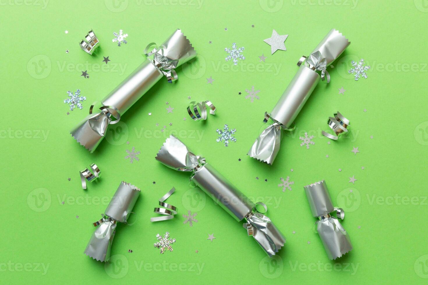 Christmas crackers with shiny confetti on color background, top view, copy space photo