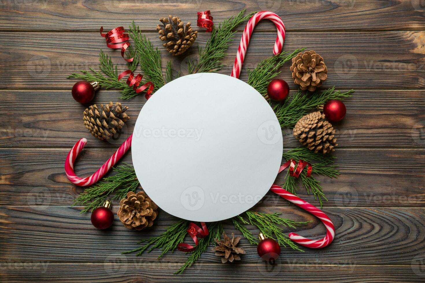 Flat lay Christmas composition. Round Paper blank, pine tree branches, christmas decorations on Colored background. Top view, copy space for text photo