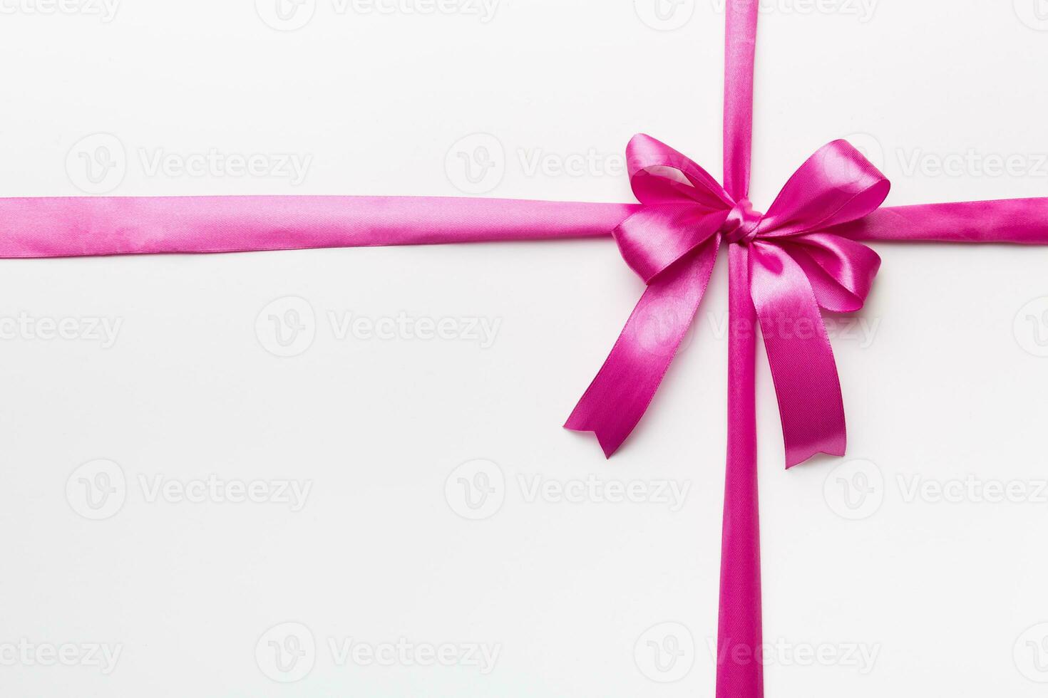 Top view of purple ribbon rolled and pink bow isolated on colored background. Flat lay with copy space photo