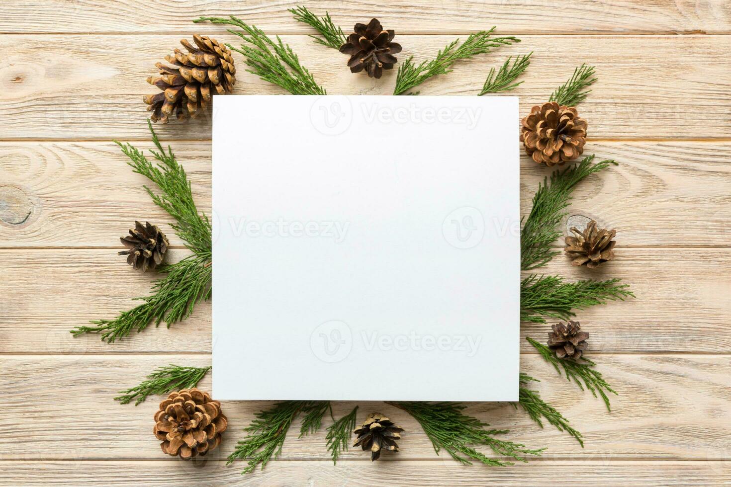 Flat lay Christmas composition. square Paper blank, pine tree branches, christmas decorations on Colored background. Top view, copy space for text photo