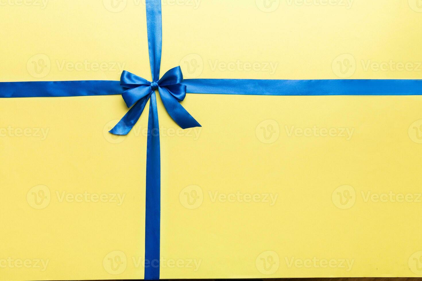 Top view of blue ribbon rolled and blue bow isolated on colored background. Flat lay with copy space photo